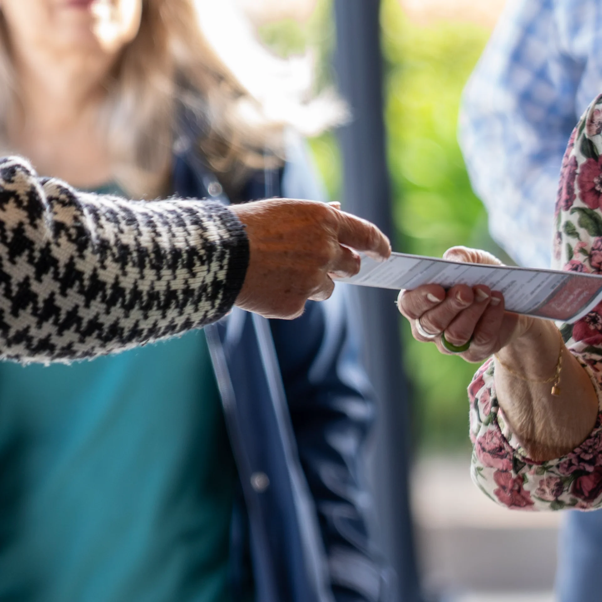 Hands passing a bulletin at GateWay